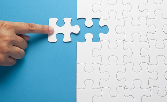 man placing last piece of puzzle