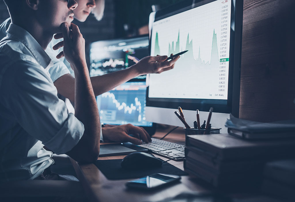workers tracking and discussing data on computer