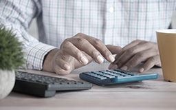 رجل يقوم بعمليات حسابية على الآلة الحاسبة