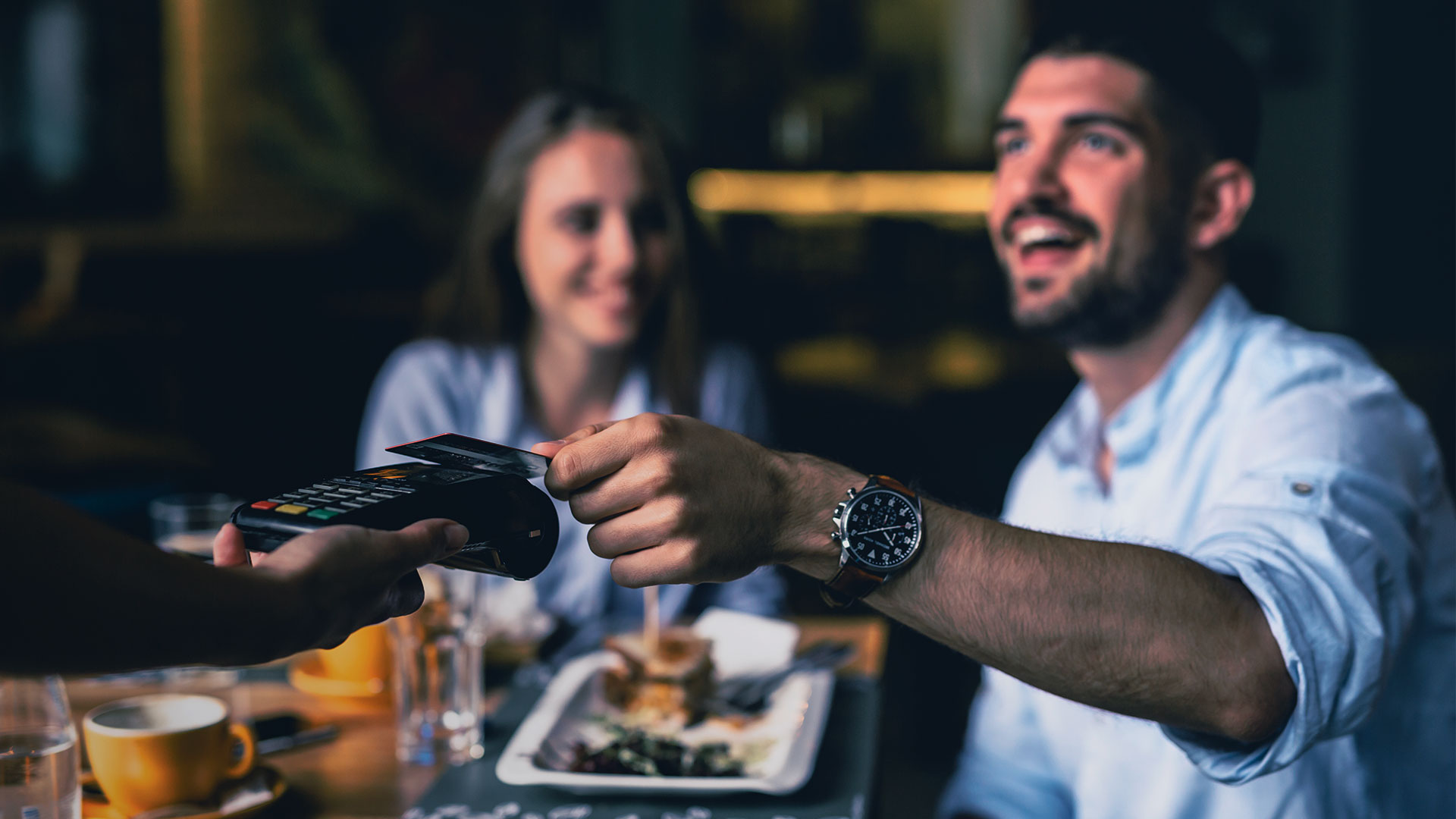 A man and a women paying their restaurant bill using credit card