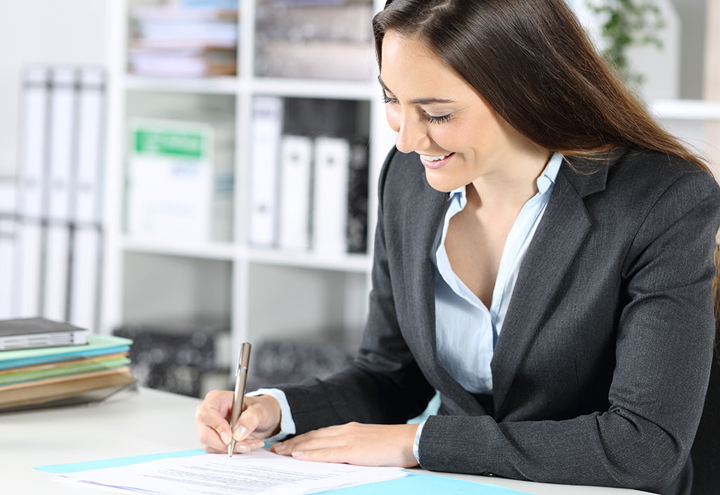 a businesswoman signing documents
