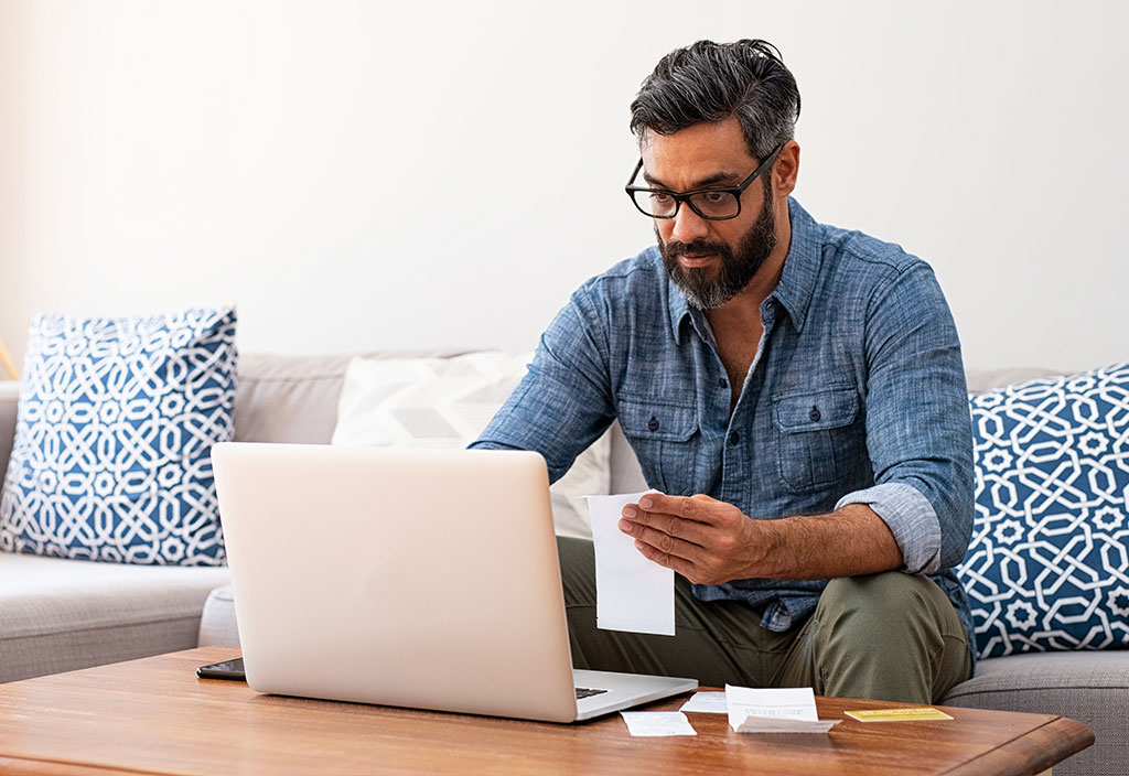a man using his laptop to control his everyday banking needs