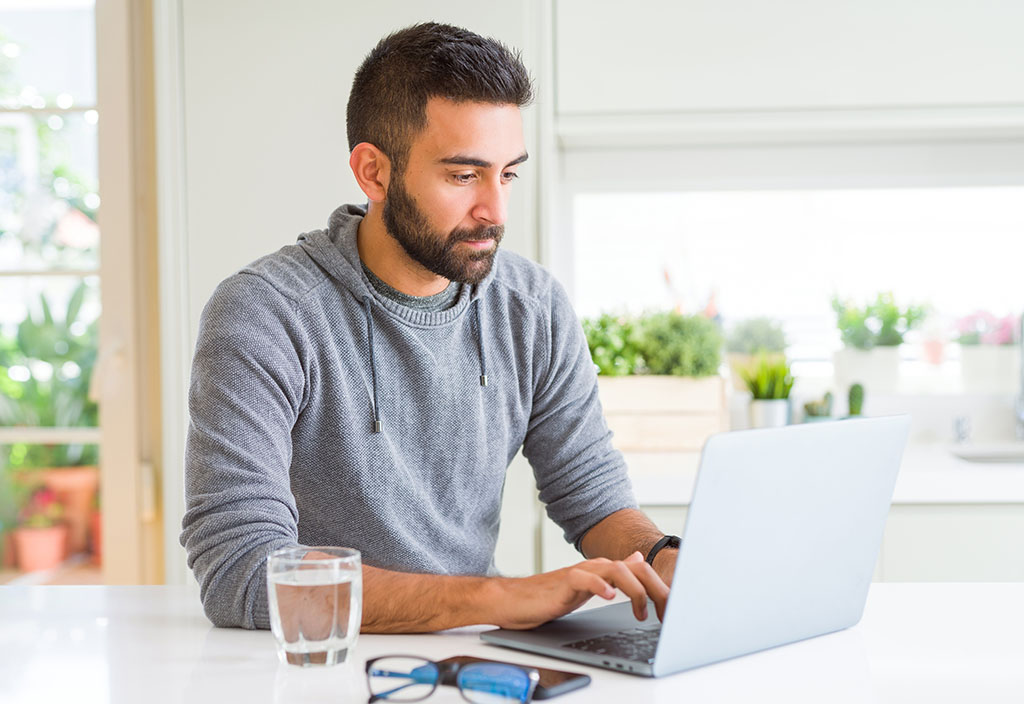 a man using his laptop to view his account details 
