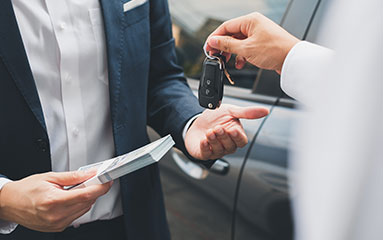 a client paying for a new car and taking its key 