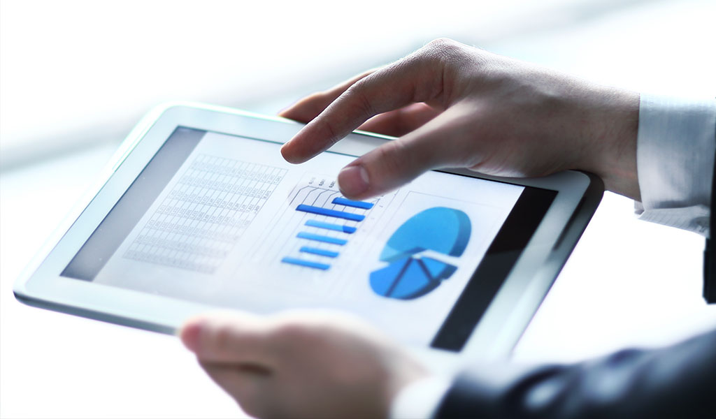 businessman reviewing statistics on his tablet