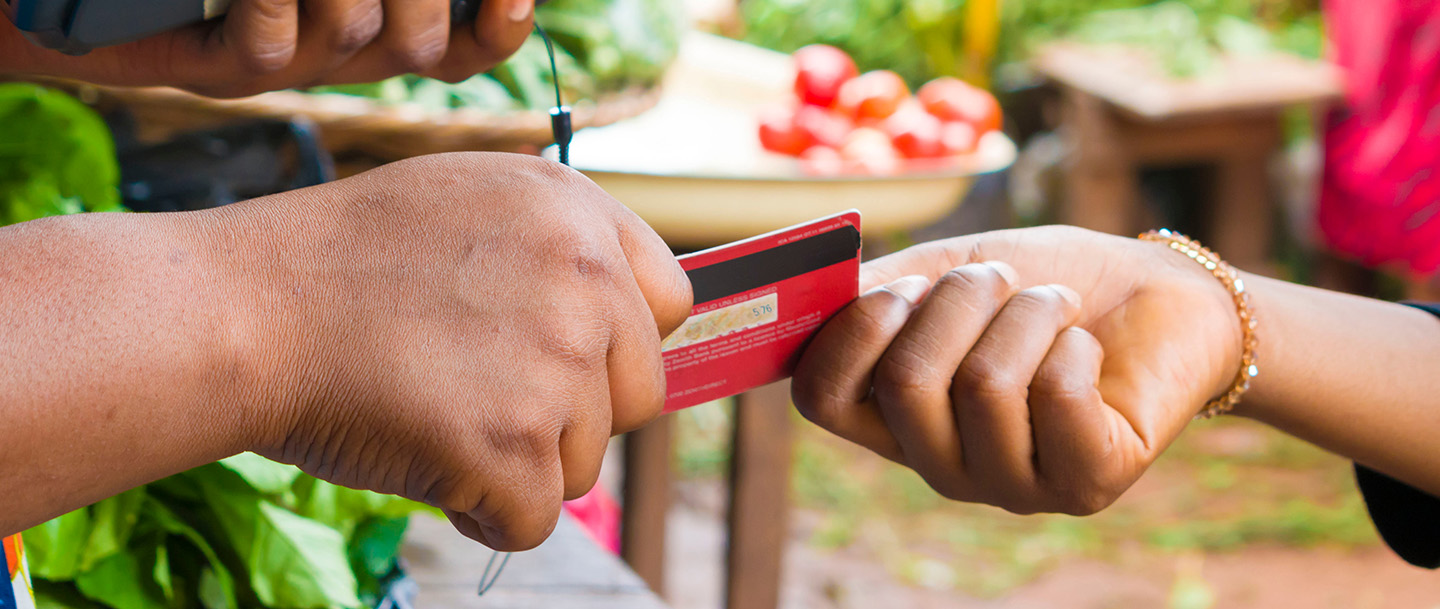 عميلة تستخدم بطاقة الخصم الخاصة بها للدفع في السوق