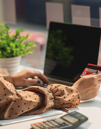 a woman entering her cards details into her laptop